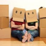 Couple moving with boxes on their heads.